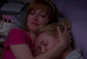 Izzie y su madre se abrazan.