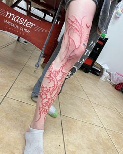 Grimes Debuts Massive Red Leg Tattoo