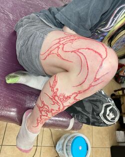 Grimes Debuts Massive Red Leg Tattoo