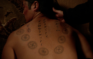 The tattoos on his back