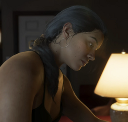 Lucia assise dans le motel dans le premier trailer.