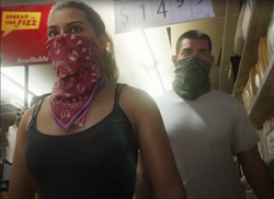 Lucia marchant à côté de son complice dans un commerce dans le premier trailer.