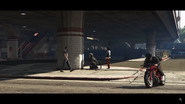 Solomun drives through a gas station parking area as the Space Monkey Street Artist sprays on a wall. Willy is watching him sparying and Jesco White is passing by.