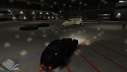 Inside the hangar. Molly and Devin are found, along with their private jet and numerous other cars.