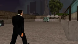 The scene cuts back to Toni walking towards the warehouse.