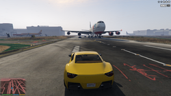 Yet another plane landing on the airport, as the chase passes straight under the landing aircraft. A police car is hit by the plane's engine.