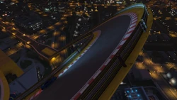 A banked 180-degree corner leads down a descending track piece