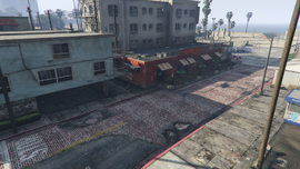 Location in Vespucci Beach. The target will flee from the alleyway to the left of the red building.