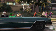 Franklin shoots at nearby Ballas while driving a Manana in GTA V.