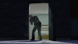 A police officer opens the rooftop entrance while trying to escape the smoke, before passing out.