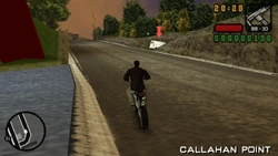 Suddenly he drives through a dirt track into the woods.