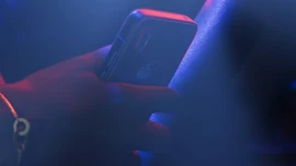 Lucia Caminos holding an iFruit phone in an official screenshot.
