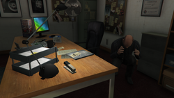 Simeon cowering in the showroom office during the Business Battle in Grand Theft Auto Online.