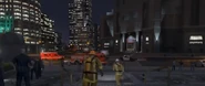 The scene outside the FIB Building with the LSPD guarding the perimeter and an Ambulance arriving.