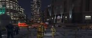 The scene outside the FIB Building with the LSPD guarding the perimeter and an Ambulance arriving.