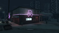 The Triangle Club at night with bright pink neon bands.