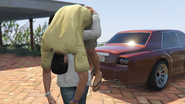 The unconscious lawyer being taken to the trunk of his car by the Protagonist.