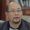 Adult man with rectangular glasses, brown eyes, very short black hair (balding), a chinstrap beard and a goatee.