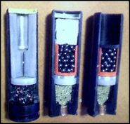 Cutaway of 12-Gague single flechette round next to buckshot rounds.