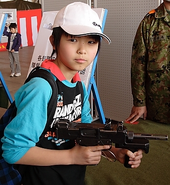 A Japanese school boy holding an unloaded PM-9.