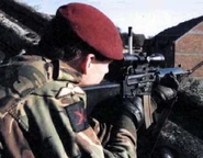 Paratrooper testing AR-18 with scope.