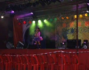 A girl performs on stage during Ghost Festival in Kuala Lumpur, Malaysia. Nobody is sitting in the red plastic chairs because the front row is reserved for ghosts.