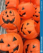 Plastic-halloween-pumpkins-display-white-wire-basket-full-jack-o-lanterns-used-children-to-gather-candy-127728620