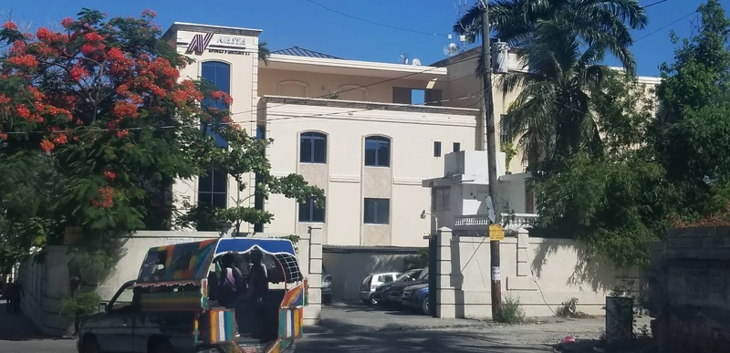 A classic Port-au-Prince tap-tap glides by the INASSA office complex in Canapé Vert