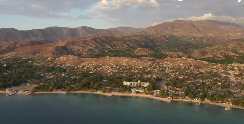 Sunset over the Montrouis waterfront, with the town stretching along the shoreline of the  and low foothills rising quickly toward the interior mountains.