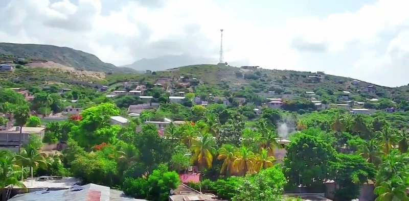 Hillside neighborhoods in the interior of the Délugé section, showing dispersed housing and vegetation above the coastal plain.
