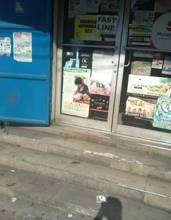 A modest entrance in Nazon—marked with beauty posters, money-transfer services, and everyday errands show the texture of the district’s commercial corridors.