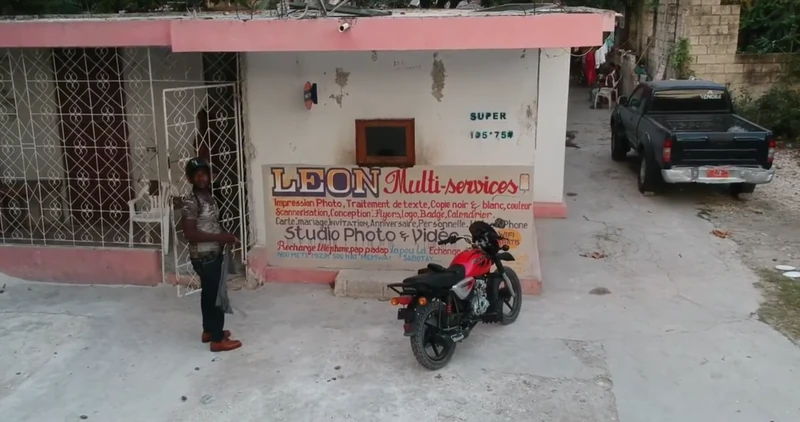 LEON Multi-services storefront in Ca-Ira, Léogâne, providing photo printing, document services, mobile recharge, and digital support.