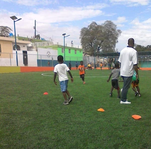 Coaching and playtime on a community field in Baillergeau.