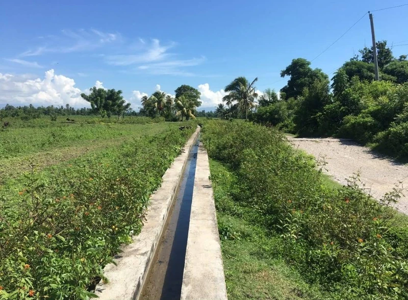 An irrigation canal cutting through the Torbeck plains, supporting the vegetable plots and open fields that spread across the southern lowlands.