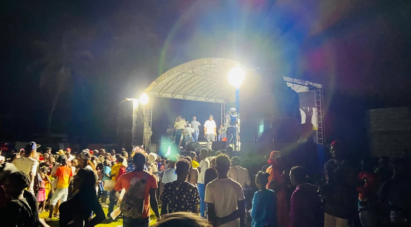 Evening crowd gathered around the stage - a full crowd out in Petit-Harpon for a night of music and vibes.
