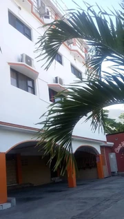 Mondesir Hotel in Canapé Vert, with its bar-resto tucked beneath the arches and the palm-lined courtyard out front.