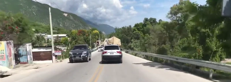 Traffic along the busy coastal corridor Route Nationale 1 near Délugé, between Saint-Marc and Montrouis.