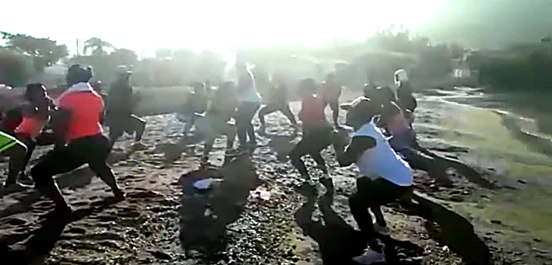 As the sun climbs over the Gulf of Gonâve, people gather along the Ça-Ira shoreline for group fitness sessions.