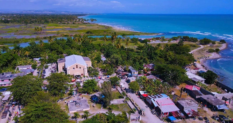 An aerial view of central Torbeck, with Saint-Joseph Church in the foreground and Gaby Beach just above the river mouth along the shoreline.