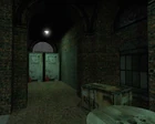 The hallway seen in the Get Your Free TVs! official screenshot (seen from the same spot). Note that the car has been replaced with an early brush APC (here hidden by the closed doors), and some junk lies near the doorway.