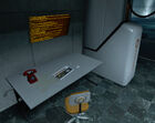 Desk and Aperture Science Red Phone in the lobby of GLaDOS' Cchamber.