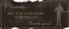 "Please... Wait for attendant to being lift. Thank you!" sign featured at the bottom of the elevator shaft.