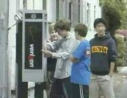 Players wait at a payphone.