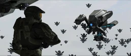 Страж Агрессор приближается к Джону-117, в то время как массивная группа Стражей собирается на заднем плане.