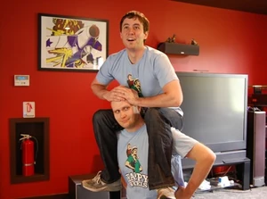 Two people with T-Shirts piggyback riding.