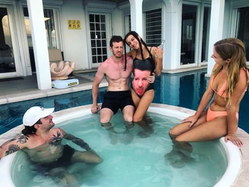 Jim in a hot tub with friends. Notice the one piece suit with his face on it.