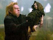Peter Pettigrew holding Voldemort's rudimentary body.jpg