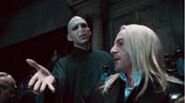 Lucius Malfoy muss Lord Voldemort seinen Zauberstab geben.