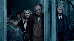 Vilder en anderen kijken grimmig toe hoe Harry's "dode lichaam" wordt gepresenteerd