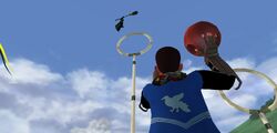 Andre throwing Quaffle towards Jacob's sibling hanging on their broomstick